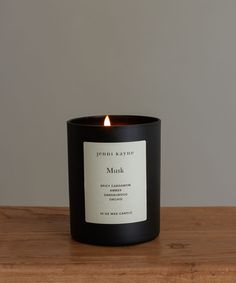 a black candle sitting on top of a wooden table