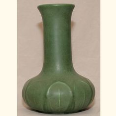 a green vase sitting on top of a table