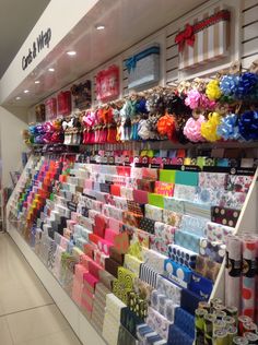 there are many items on the wall in this store that is decorated with ribbons and bows