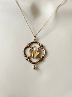 An absolutely glorious vintage necklace.  Hallmarked 9ct gold.  Art Nouveau in style, dating to around the 1960s. Delicate, exquisite details, with a sweet dangling ball drop. Reminds me of the birth of Venus, or something that would adorn a mermaid.  All solid 9ct gold. The pearl is a faux pearl. I am happy to replace with a genuine freshwater pearl if you prefer.  Chain: 16 inches Pendant: a little over 2cm wide  Rare & special ~ Vintage Round Necklace With Pearl Charm, Vintage Pearl Charm Jewelry For Anniversary, Vintage Jewelry With Pearl Charm Round Pendant, Vintage Jewelry With Pearl Charm For Anniversary, Gold Art Deco Necklace With Pearl Pendant, Heirloom 14k Gold Necklace With Pearl Pendant, Vintage Gold Pearl Drop Necklace, Vintage Round Pearl Drop Jewelry, Vintage Round Pearl Drop Necklace