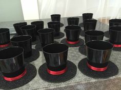 black cups with red rims are sitting on a table