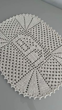 a crocheted doily is shown on a gray tablecloth that has been placed in the shape of a star