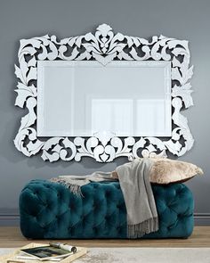 a blue couch sitting in front of a white mirror