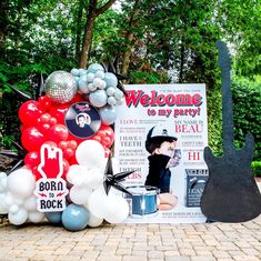 a welcome sign and balloons are on display in front of a rock band themed birthday party