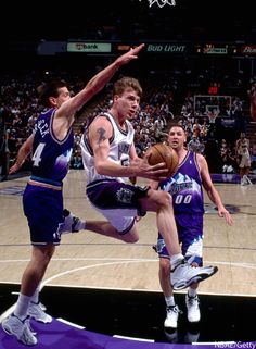 the basketball players are trying to block the ball from going into the basket in front of them