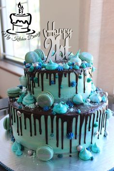 a birthday cake with blue frosting and chocolate drips