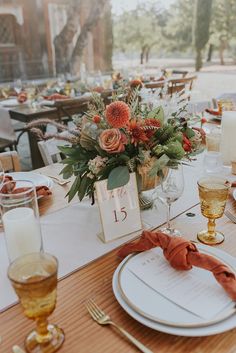 the table is set with flowers and candles