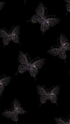 a black background with silver butterflies on it