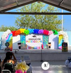 an outdoor stage set up with balloons and decorations