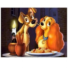 lady and the tramp eating spaghetti together in front of a lit candle on a table