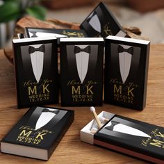 four black and white wedding guest book sets with a pen in the middle one has a bow tie on it