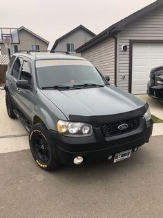 a black suv parked in front of a house