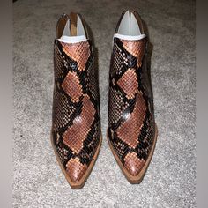 A Split Shaft Adds A Distinctive, Modern Touch To A Pointy-Toe Bootie Set On A Lofty Stacked Heel. - Pointed Toe - Covered Vamp - Snakeskin Embossed Upper - Back Zip Closure - Notched Sides - Stacked Block Heel Western Style Medium Width Heels With Pointed Toe, Brown Heels With Medium Width And Snip Toe, Brown Pointed Toe Heels With Heel Pull Tab, Snake Print Leather Boots With Pointed Toe, Snake Print Boots With Medium Width And Almond Toe, Snake Print Boots With Almond Toe And Medium Width, Medium Width Leather Snake Print Heels, Brown Leather Snake Print Heels, Snake Print Pointed Toe Heels Medium Width