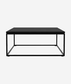 a black coffee table sitting on top of a white wall