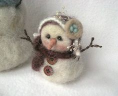 a snowman ornament made out of wool with buttons on it's nose