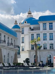 a large white building with blue domes on it's roof and some palm trees