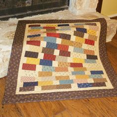 a quilt on the floor in front of a fireplace