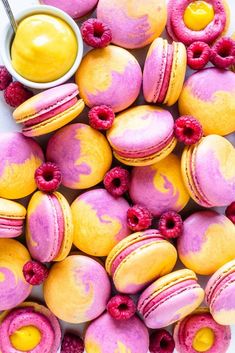 colorful macaroons with raspberries and lemon sauce