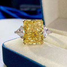 a fancy yellow diamond ring in a box