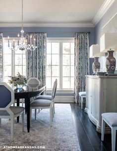 a dining room with blue walls and curtains