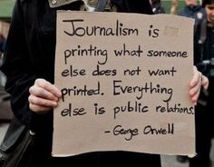 a person holding a sign that says, journalist is printing what someone else does not want printed everything else is public relations