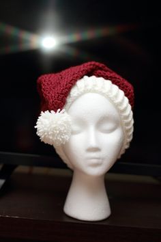 "Crochet Santa hat in ivory and cranberry. Created using the Red Heart pattern.  Size large (adult)  Hat circumference approx 20\" stretches to 23\".  Made using 100% Acrylic yarn (Hobby Lobby I Love this Yarn)  Machine wash cold, lay flat to dry.  If you have any questions feel free to ask. Matching Christmas Stocking coming soon." Red Adjustable Christmas Hat, Adjustable Red Christmas Hat, Adjustable Red Hats For Holiday, Adjustable Red Hat For Holiday, Winter White Crochet Hat As Gift, White Crochet Hat For Winter Gift, Red Hat As A Gift, One Size Fits All, Red Hat As A Gift, White Crochet Beanie Hat As Gift