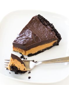 a piece of chocolate cheesecake on a plate with a fork next to the slice