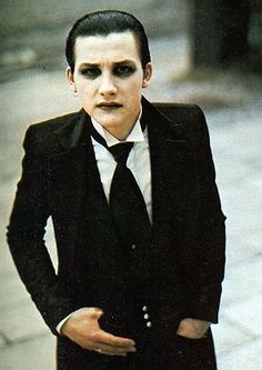 a man in a suit and tie with his hands on his hips wearing fake makeup