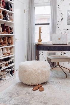 a white ottoman sitting on top of a rug in front of a closet filled with shoes