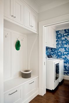 a white washer and dryer in a room with blue wallpaper on the walls