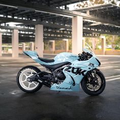 a blue motorcycle parked in an empty parking lot