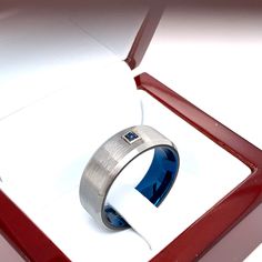 This simple and elegant Tungsten Wedding Band with blue interior may become a favorite piece for many years. In the center of this Tungsten Wedding Band there is a beautiful square Garnet that has a rich deep hue of brownish red. The gemstone is set in a solid gold bezel. You can request different birthstones or any other precious stones . This ring measures 8mm in width. The profile of the ring is flat with beveled edges and satin finished texture. The inner part is rounded for Comfort Fit. Thi Modern Sapphire Wedding Rings, Modern Blue Sapphire Promise Ring, Mens Sapphire Ring, Blue Tungsten Ring, Mens Wedding Rings Tungsten, Blue Wedding Band, Sapphire Wedding Band, Tungsten Mens Rings, Sapphire Band