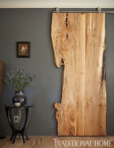 a large piece of wood sitting on top of a wooden floor next to a table