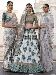 three women in white and blue outfits standing next to each other with their hands on their hips