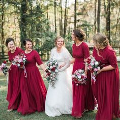 a group of women standing next to each other on top of a lush green field