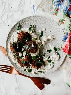 a white plate topped with meatballs and mashed potatoes