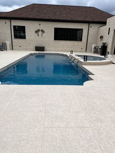 an empty swimming pool in front of a house