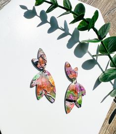 Handmade polymer clay fairy wing earrings in orange and purple! These are perfect for those cottagecore vibes! Each pair of earrings are handmade to order, so please expect minor variations. This makes each design unique! Made from high quality polymer clay that is lightweight for all day comfort.  Ear posts are stainless steel and hypoallergenic, making them perfect for sensitive ears. PROCESSING TIME:  Please note our processing time before placing an order. Processing time is 1-3 business day Whimsical Multicolor Polymer Clay Earrings, Fairycore Birthday, Earrings Fairycore, Fairy Wing Earrings, Fall Cottagecore, Orange Marble, Cottagecore Earrings, Clay Fairy, Polymer Clay Fairy