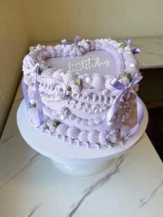 a large white cake with purple ribbon around it