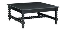 a black coffee table with wooden legs and an ornate design on the top, against a white background