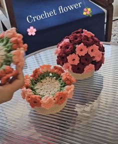 three crocheted flower baskets sitting on top of a table