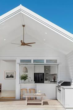 a white house with a ceiling fan in the kitchen