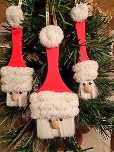 two red and white christmas ornaments hanging from a tree