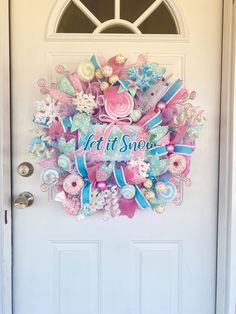 a door with a wreath on it that says, let it snow and some flowers