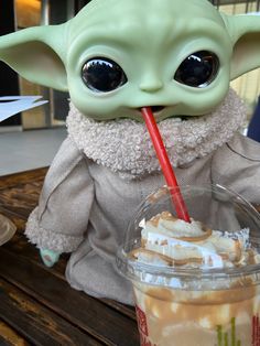 a baby yogurt drink with a straw in it's mouth sitting on a table