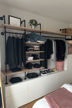 an organized bedroom with clothes and shoes on shelves