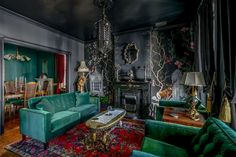 a living room filled with green couches and chairs next to a fire place in a fireplace