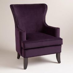 an upholstered purple chair with studding on the armrests and legs