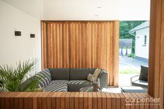 a living room filled with furniture next to a wooden wall