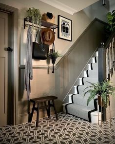 the stairs are decorated with potted plants and pictures on the wall above them, along with a bench